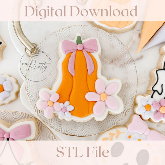 Decorative cookie with pumpkin and flowers on a white plate, surrounded by other cookies.