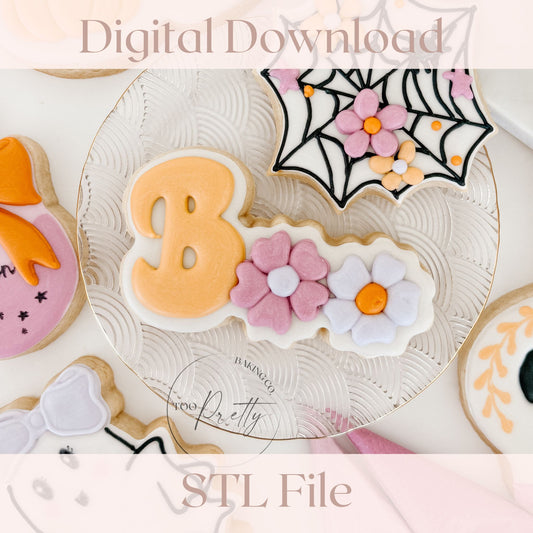 Decorated cookie that reads "BOO" with floral details.